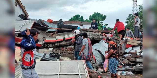 Residents inspect the ruins of a building destroyed by an earthquake in Mamuju, West Sulawesi, Indonesia, Saturday, January 16, 2021 (AP Photo / Yusuf Wahil)